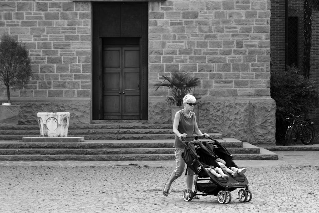 Parent pushing the best double strollers with two children showing side-by-side and tandem stroller designs