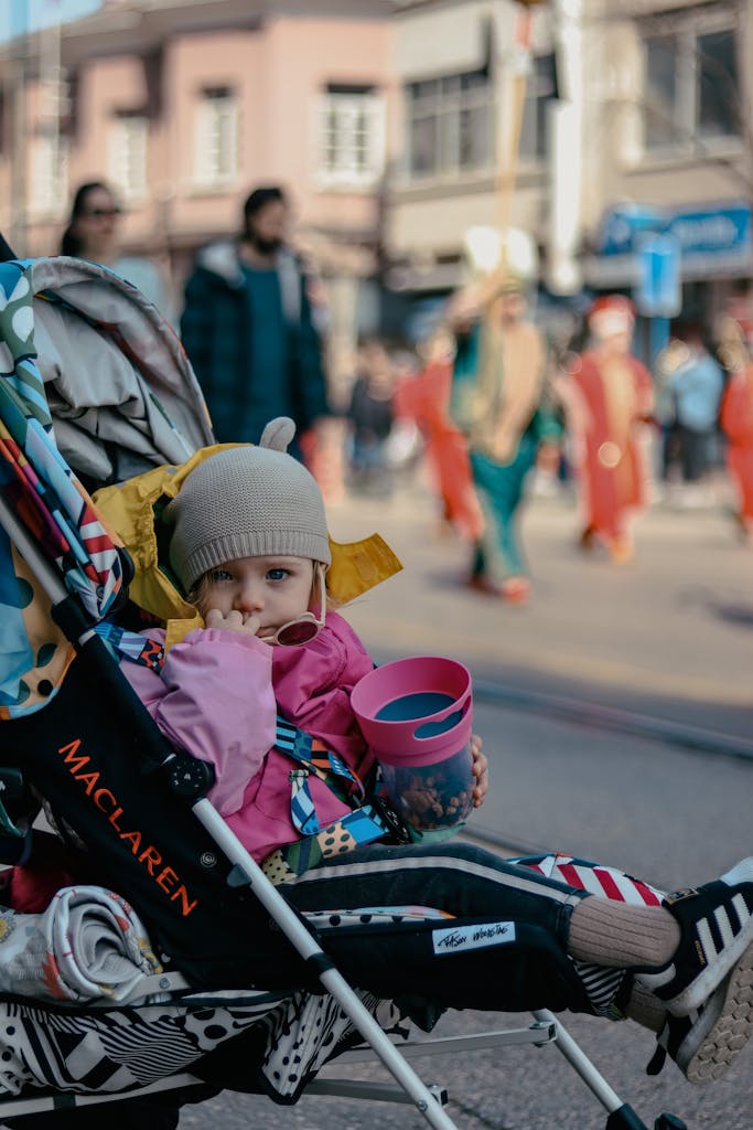Parent pushing one of the best strollers for newborn to toddler with baby in a modern travel system stroller outdoors