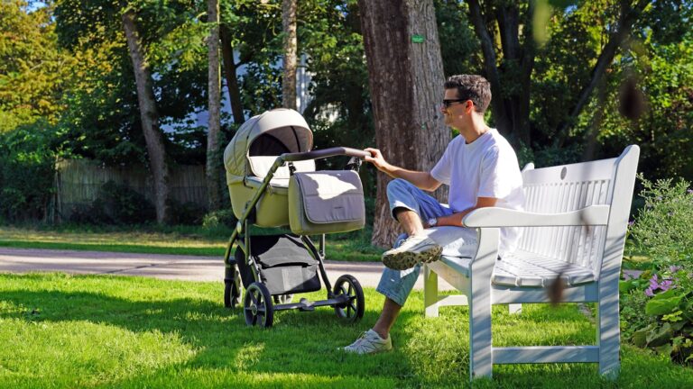 Baby sleeping comfortably in the best baby strollers for napping and a fully reclining stroller during a family walk outdoors.