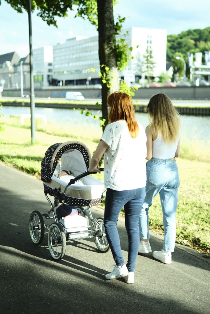 Best strollers for city living displayed on an urban sidewalk with parents walking through downtown.