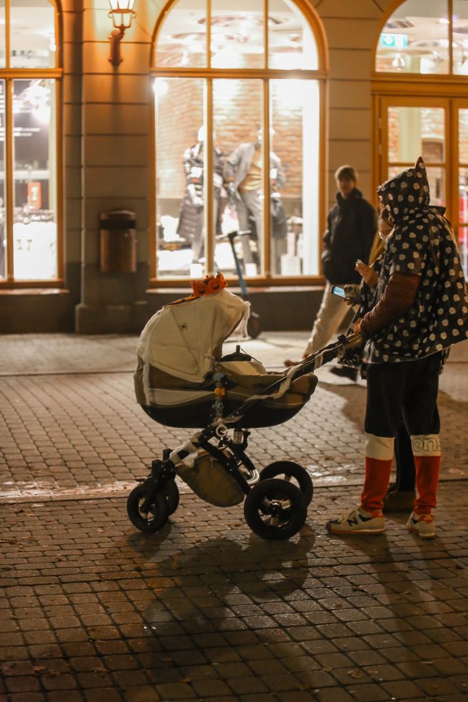 Best strollers for city living displayed on an urban sidewalk with parents walking through downtown.